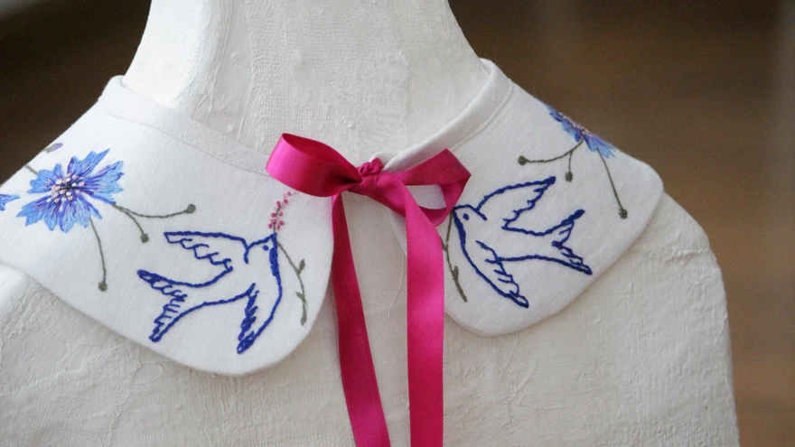 Värvilise tikandiga krael on lihtsad põllulilled, lips ja linnukesed ehk kõik armsad ja koduselt tuttavad motiivid.