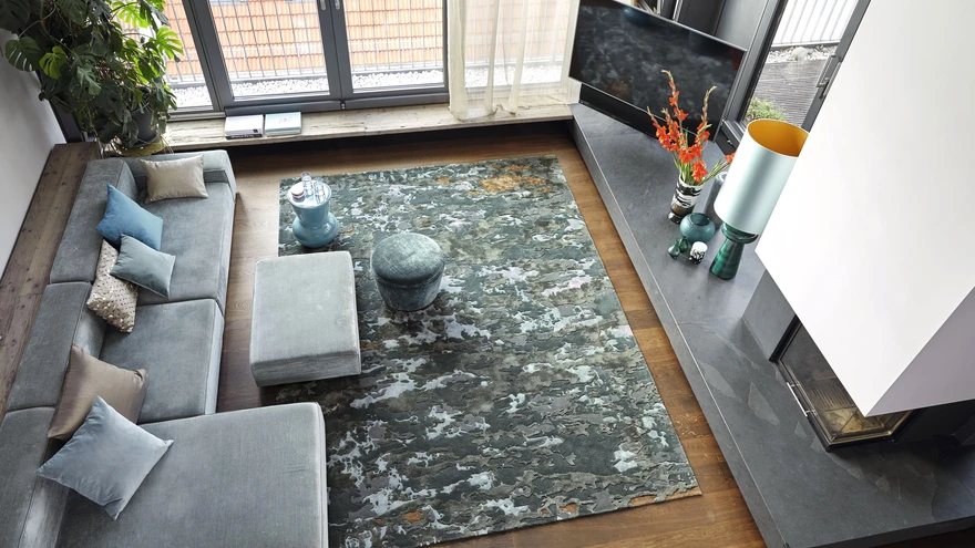 Külmades toonides villane vaip ja sametine diivan mõjuvad kokkuvõttes siiski soojalt. 